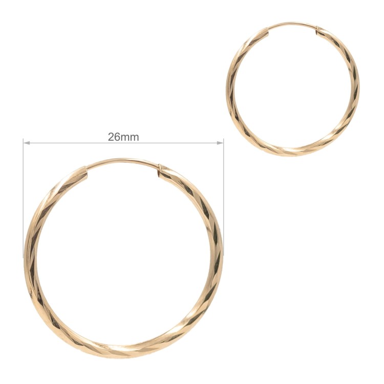 Złote kolczyki koła o skręcanej fakturze na jasnym tle wymiary
