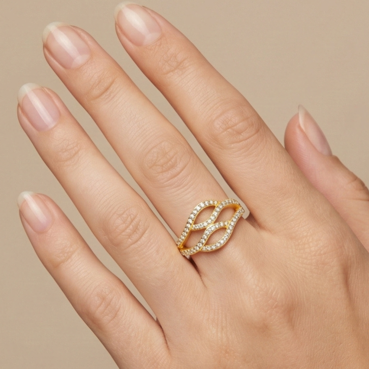 Luksusowy złoty pierścionek 585 o szerokiej, ażurowej koronie wysadzanej cyrkoniami na dłoni modelki.