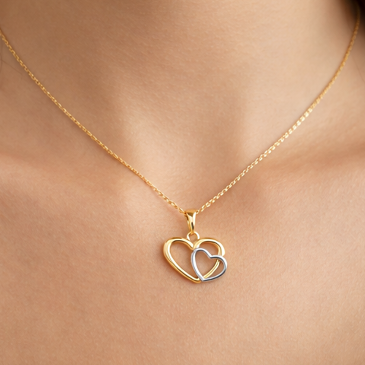 Złota zawieszka złączone serca zbliżenie na szyi