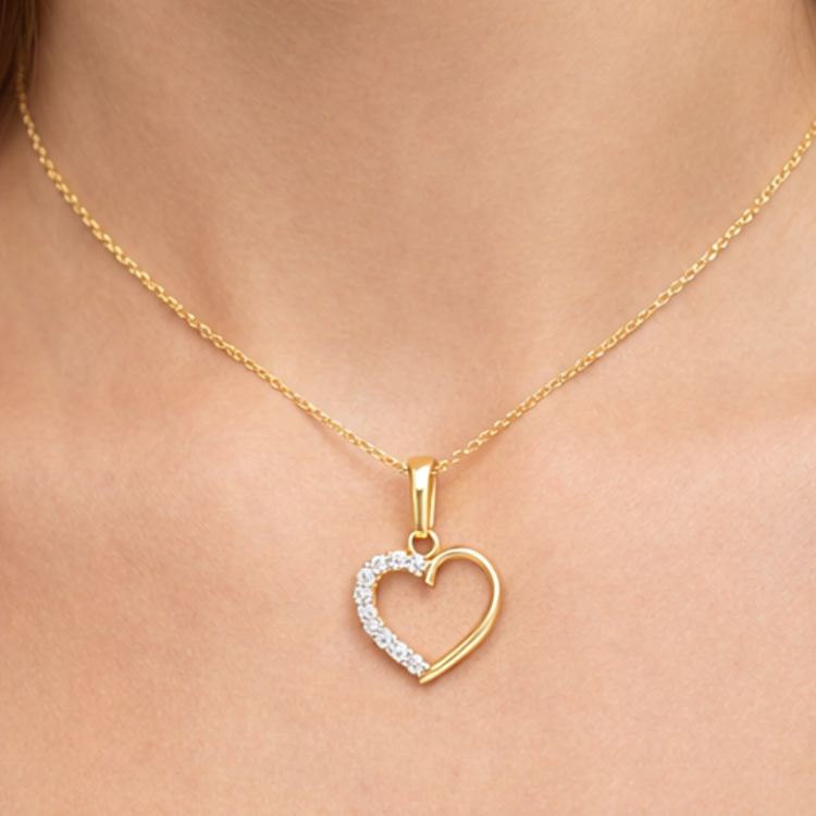 Złota zawieszka serduszko z cyrkoniami zbliżenie na szyi