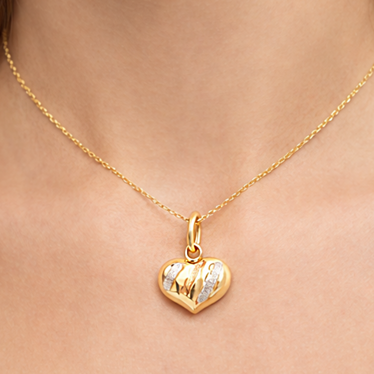 Złota zawieszka wypukłe serce zbliżenie na szyi