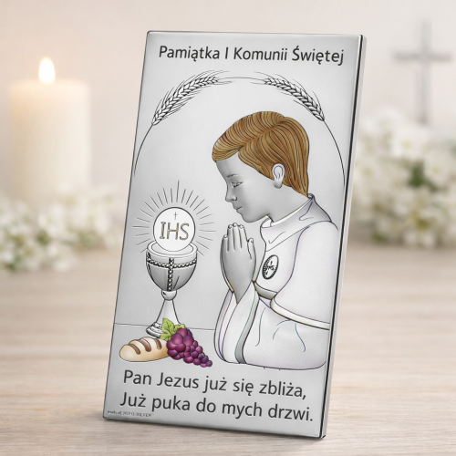 Srebrny obrazek komunijny chłopiec pod kątem na jasnej komodzie delikatne rekwizyty