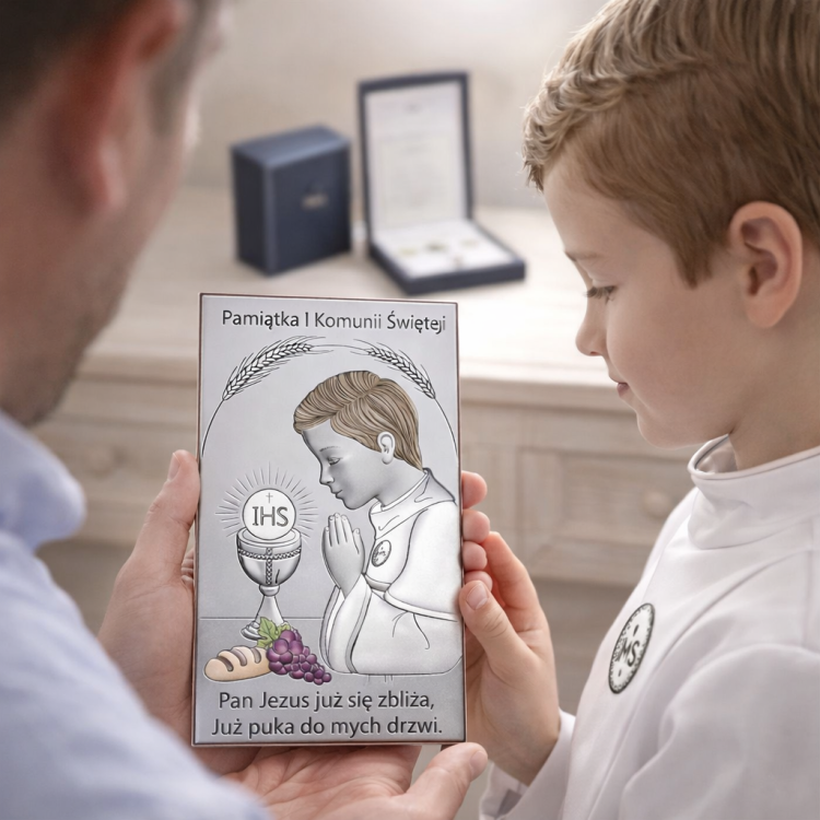 Srebrny obrazek na Komunię – rodzic trzyma pamiątkę, chłopiec ogląda, pudełko i certyfikat producenta w tle