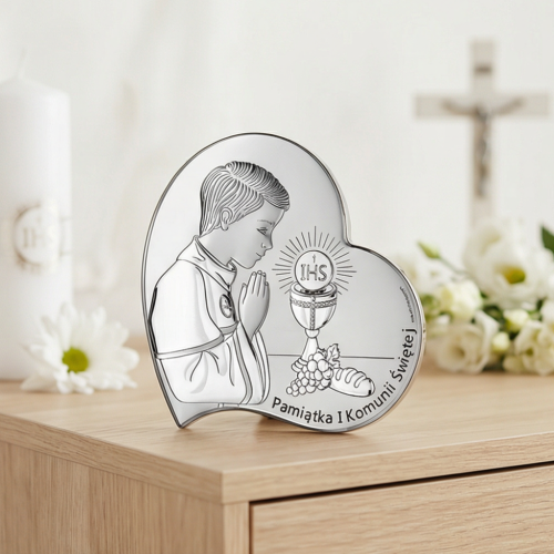 Pamiątka I Komunii Świętej dla chłopca – srebrny obrazek 925 serce z motywem IHS i kielicha w aranżacji na komodzie, krzyż w tle