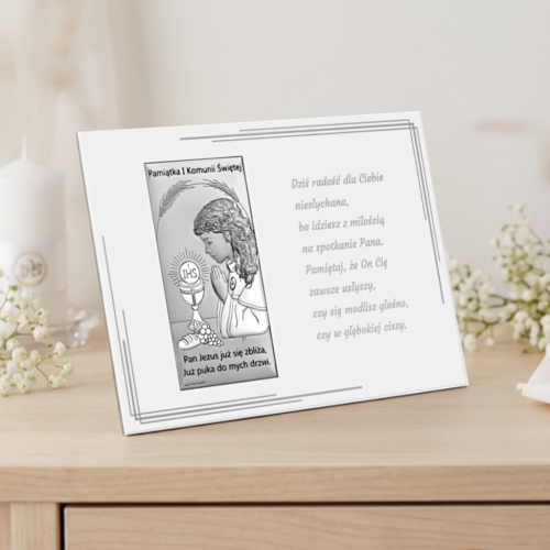 Pamiątka I Komunii Świętej w formie kartki z życzeniami i srebrnym obrazkiem komunijnym IHS – aranżacja na komodzie