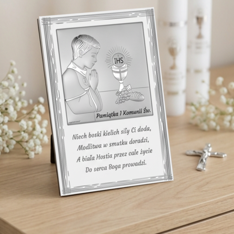 Pamiątka I Komunii Świętej – srebrny obrazek z wierszykiem dla chłopca, motyw IHS i kielicha, aranżacja na komodzie ze świecą i krzyżykiem