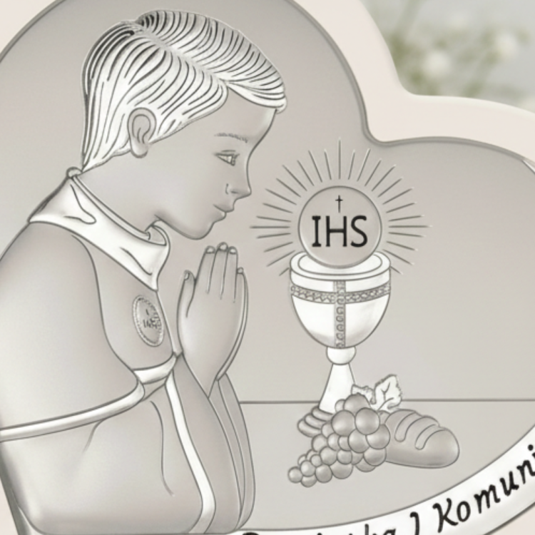 Zbliżenie na srebrny obrazek na komunię – chłopiec w modlitwie, hostia IHS nad kielichem, winogrona i chleb, detal pamiątki