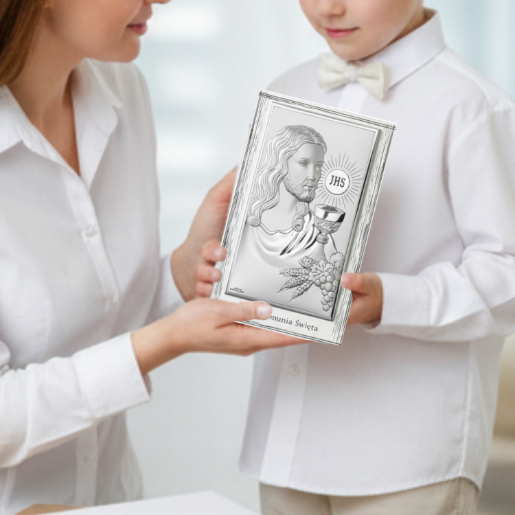 Pamiątka Pierwszej Komunii Świętej – chłopiec otrzymuje srebrny obrazek w ramce z Jezusem i napisem Moja I Komunia Święta