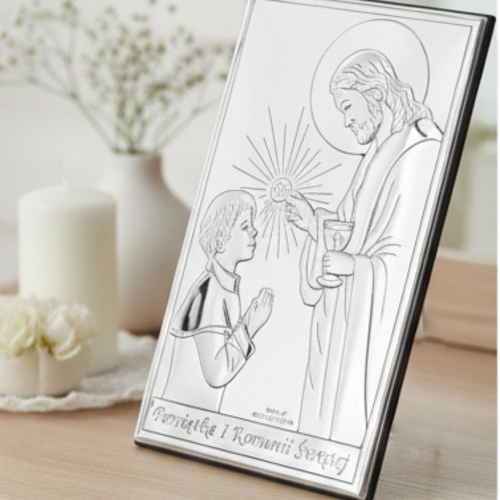 Obrazek komunijny w ramce z Jezusem udzielającym Komunii, ustawiony na komodzie przy świecy