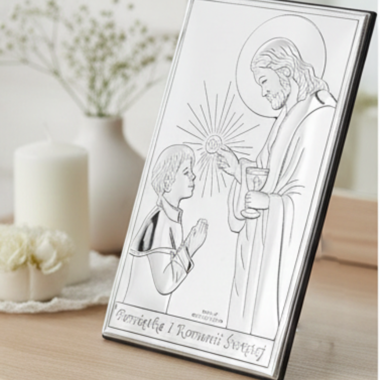 Obrazek komunijny w ramce z Jezusem udzielającym Komunii, ustawiony na komodzie przy świecy