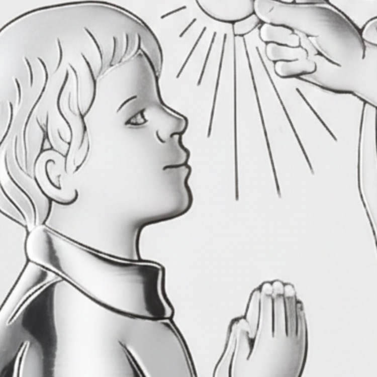 Zbliżenie na hostię z napisem JHS i modlącego się chłopca na srebrnym obrazku komunijnym