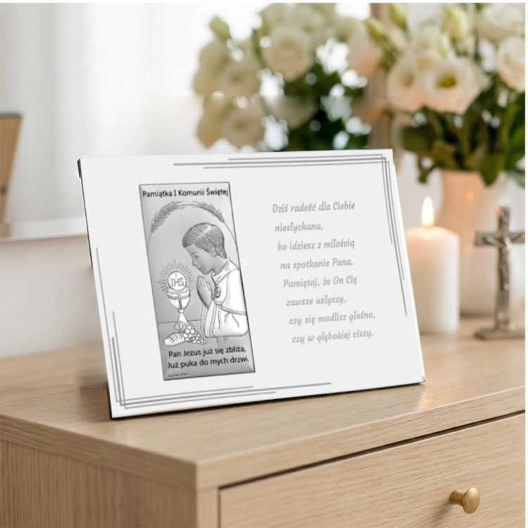 Pamiątka Pierwszej Komunii Świętej w ramce z cytatem i obrazkiem chłopca, aranżacja ze świecą i kwiatami
