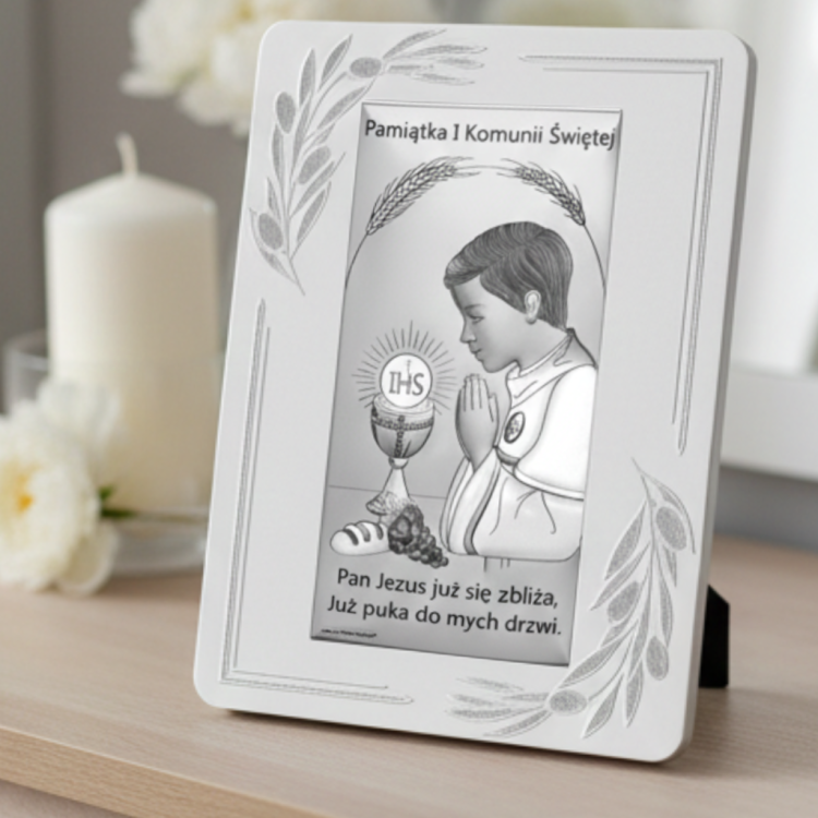 Pamiątka Pierwszej Komunii Świętej – obrazek z chłopcem w modlitwie i hostią IHS ustawiony na komodzie przy świecy