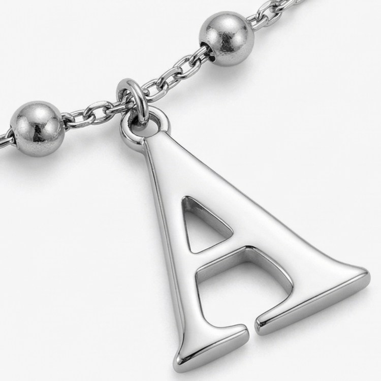 zbliżenie srebrnej zawieszki w kształcie litery A