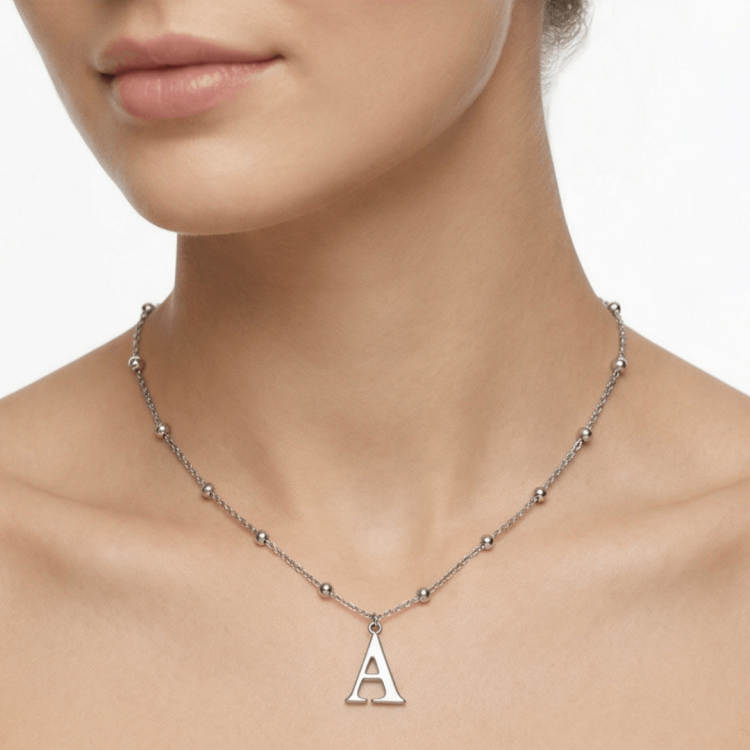 srebrny naszyjnik z literą A na szyi modelki