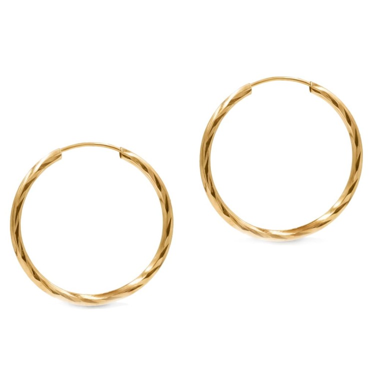 Złote kolczyki koła o skręcanej fakturze na jasnym tle