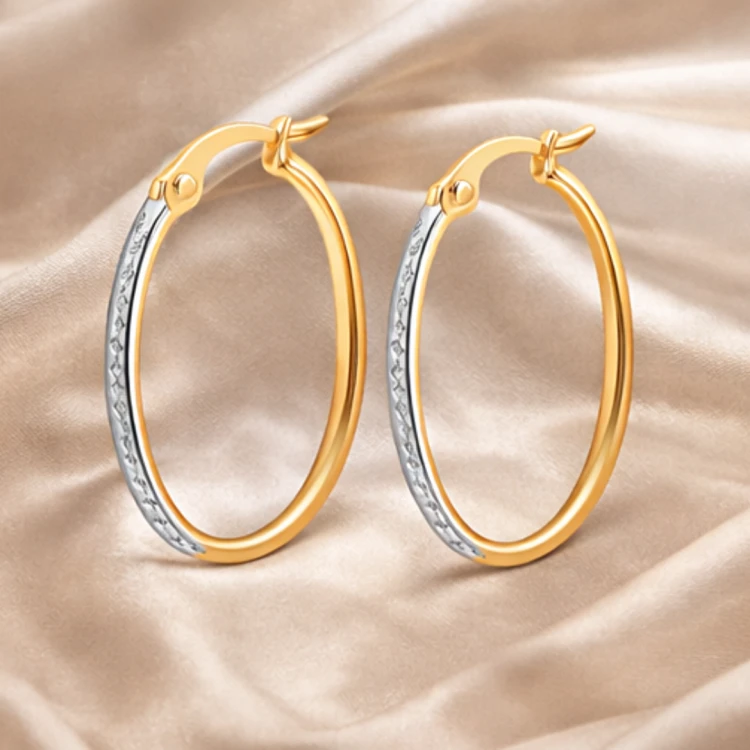 Dwukolorowe kolczyki koła o owalnym kształcie na satynowej tkaninie