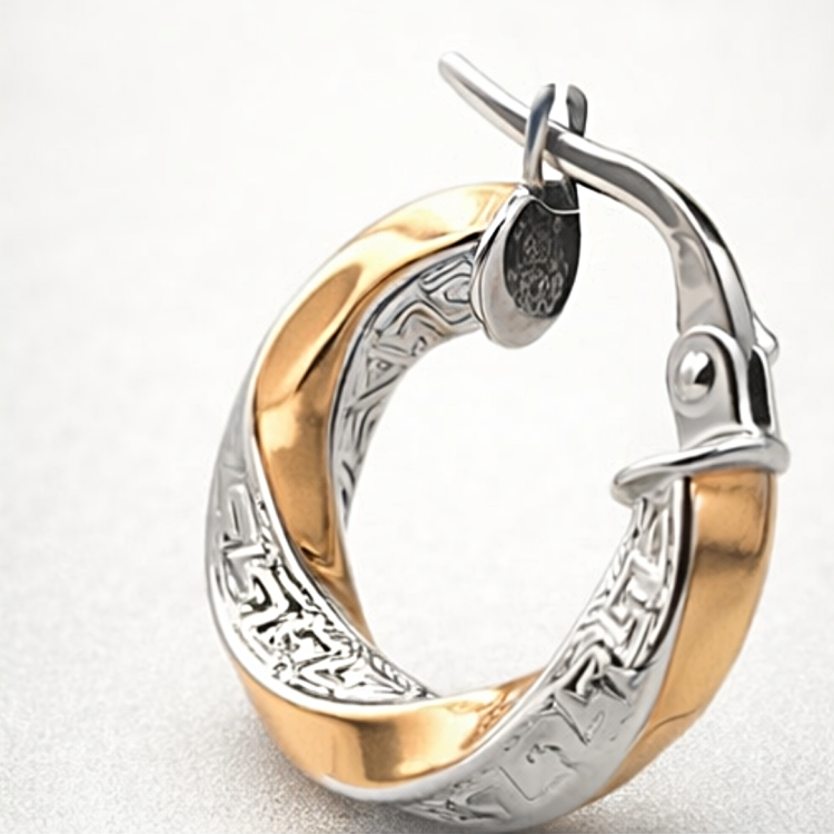 Zbliżenie na dwukolorowy kolczyk koło o skręcanej formie z ozdobnym grawerowanym wzorem i zapięciem