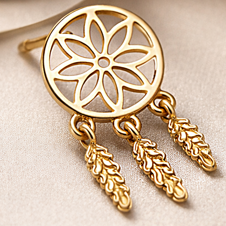 Złoty kolczyk ażurowy z motywem rozety i trzema wiszącymi piórkami w zbliżeniu