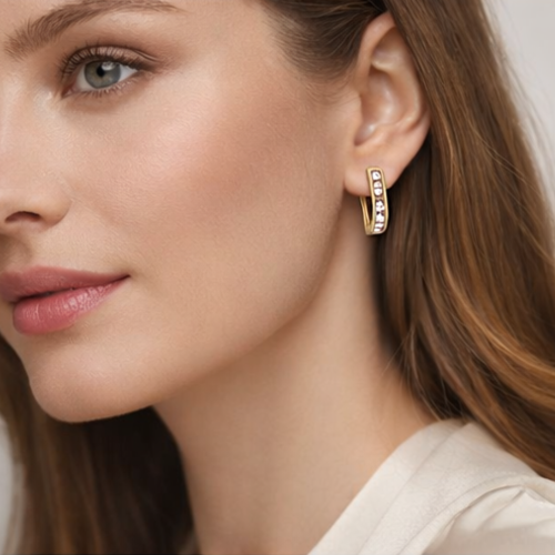 Modelka w złotych kolczykach zatrzaskowych z różowymi i białymi cyrkoniami