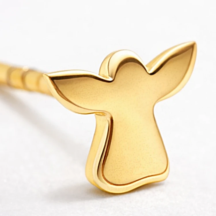 Zbliżenie złotego kolczyka sztyftu w kształcie aniołka