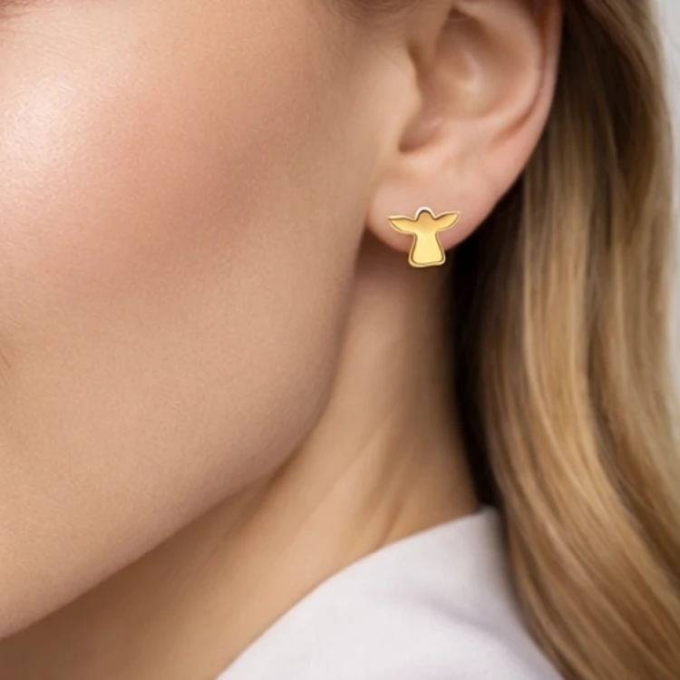 Złoty kolczyk sztyft aniołek na uchu kobiety