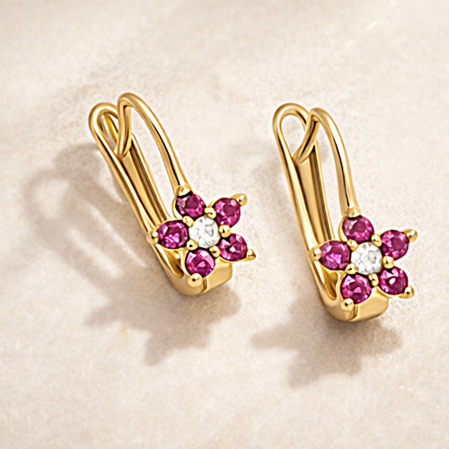 Złote kolczyki z różowym kwiatkiem i jasnym oczkiem na jasnym tle