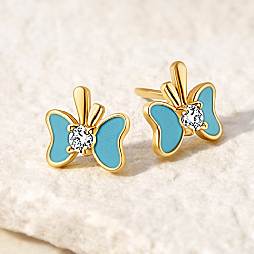 Złote kolczyki w kształcie motyla z niebieskimi skrzydłami na jasnym tle