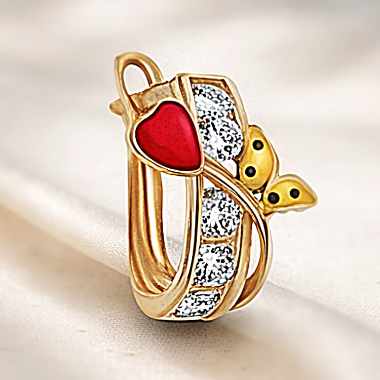 Złoty kolczyk z czerwonym serduszkiem, białymi kamieniami i żółtym akcentem w zbliżeniu