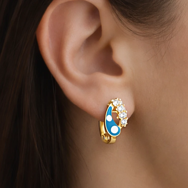 Złoty kolczyk z niebieskim motywem łezki i białymi kamieniami prezentowany na uchu