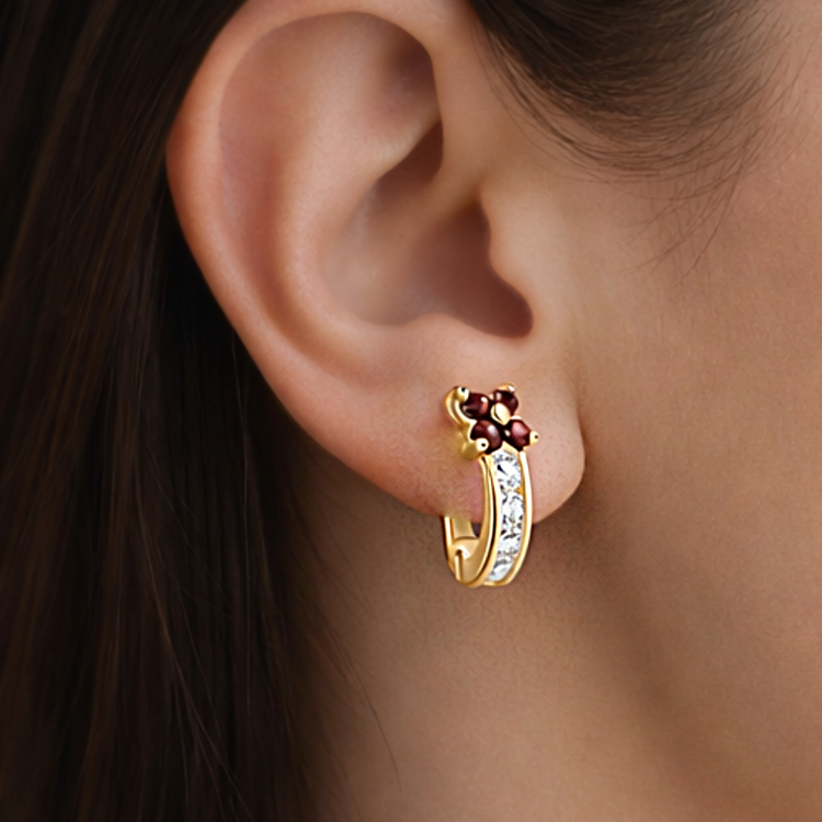 Złoty kolczyk z bordowym kwiatkiem i białymi kamieniami na uchu