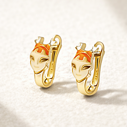 Złote kolczyki koła z pomarańczowym detalem i motywem stylizowanej twarzy na jasnym tle