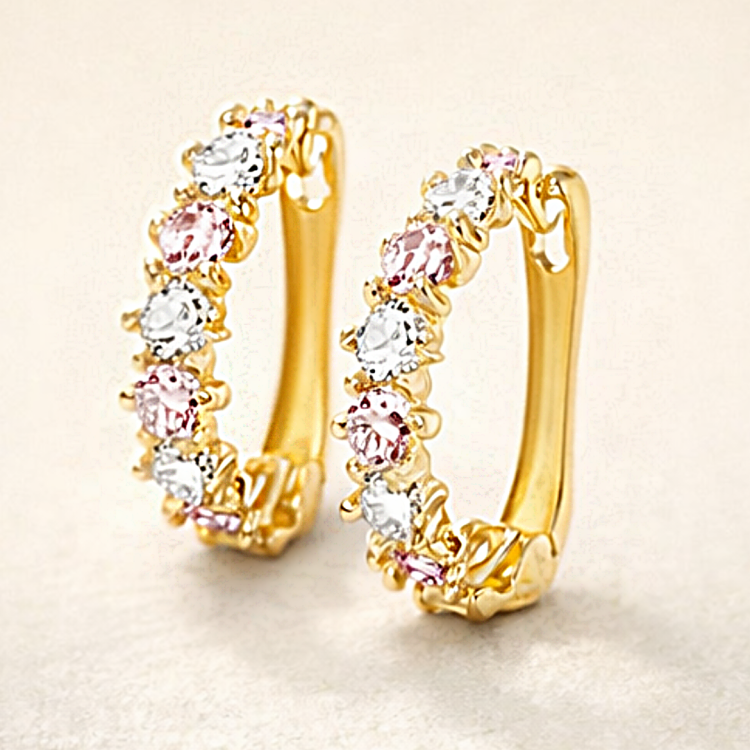 Złote kolczyki koła z różowymi i białymi kamieniami – zbliżenie pary na jasnym tle