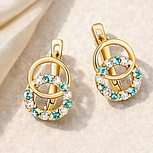 Para złotych kolczyków z okrągłą zawieszką i niebieskimi, białymi kamieniami – ujęcie pod kątem