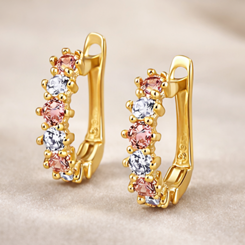 Złote kolczyki koła z różowymi i białymi kamieniami – zbliżenie pary