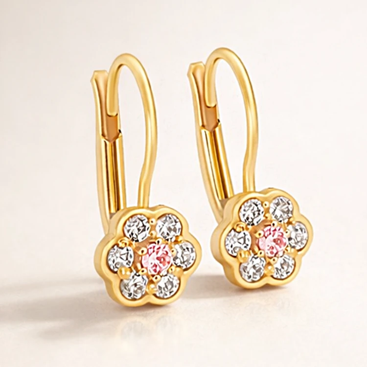 Złote kolczyki z motywem kwiatka i różowym oczkiem pośrodku – zbliżenie pary