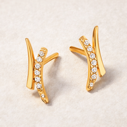 Para złotych kolczyków z falistym motywem i białymi kamieniami – ujęcie pod kątem