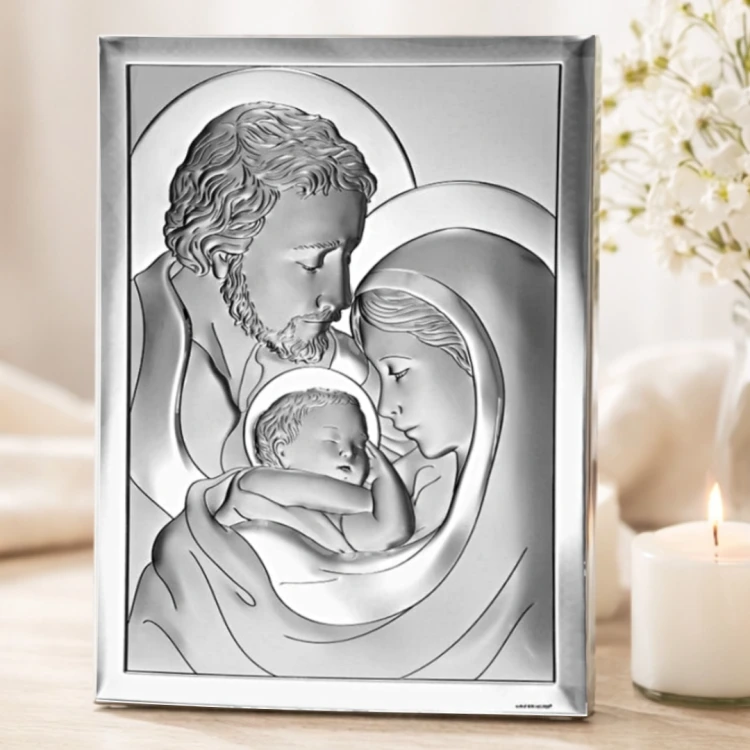 Srebrny obrazek Święta Rodzina w ramce ustawiony na drewnianym blacie