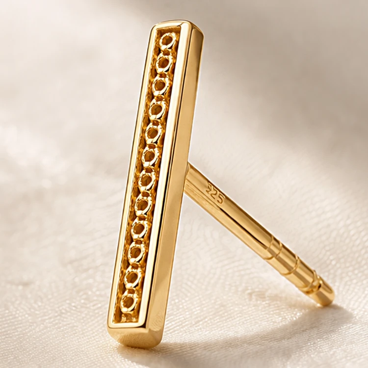 Złoty kolczyk sztyft o prostokątnym kształcie z dekoracyjnym ażurowym detalem – zbliżenie