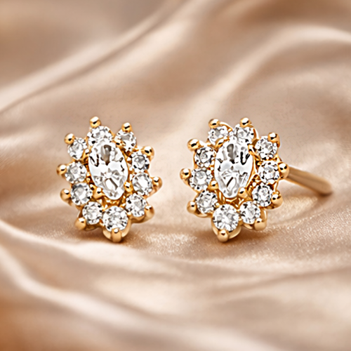 Złote kolczyki sztyfty z owalną cyrkonią i ozdobnym halo na satynowym tle