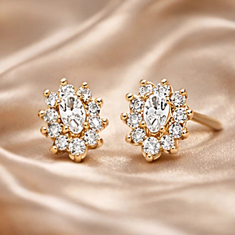 Złote kolczyki sztyfty z owalną cyrkonią i ozdobnym halo na satynowym tle