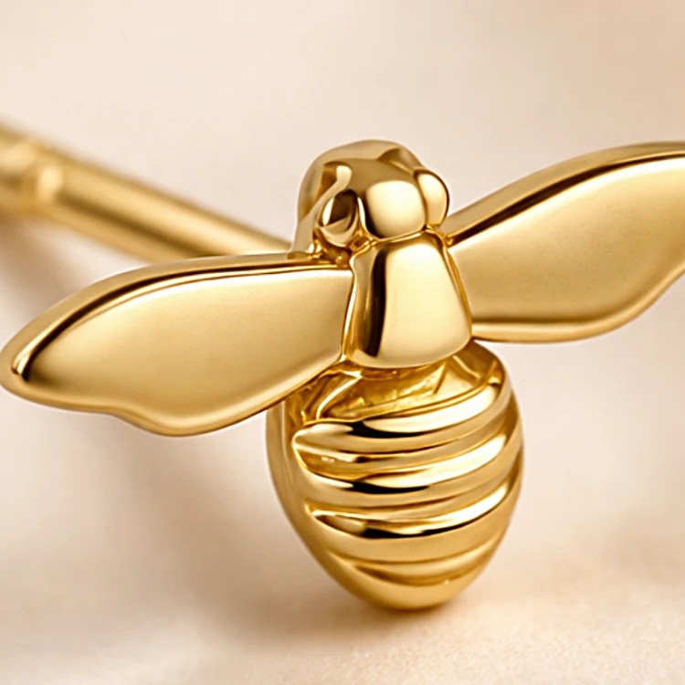 Zbliżenie złotego kolczyka pszczoły o polerowanym wykończeniu