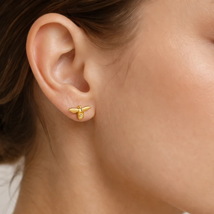 Złoty kolczyk pszczoła na uchu – delikatna biżuteria damska