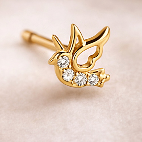 Zbliżenie złotego kolczyka jaskółki zdobionego białymi cyrkoniami