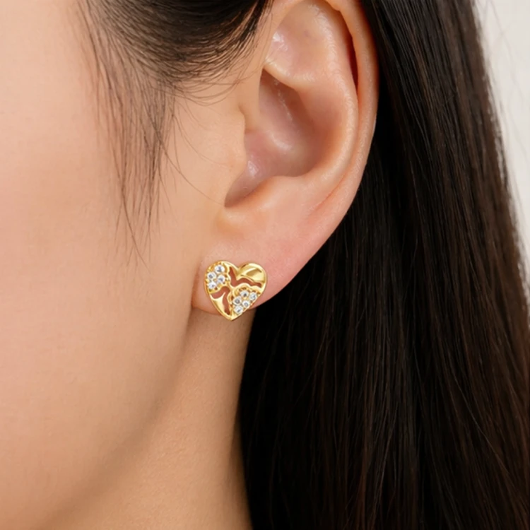 Złoty kolczyk serce z cyrkoniami na uchu