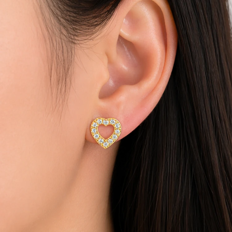 Złoty kolczyk serce z cyrkoniami na uchu